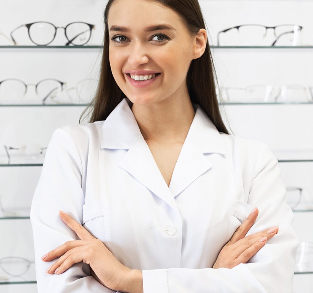 happy-female-optometrist-standing-in-optics-store-BKUQXKH.jpg