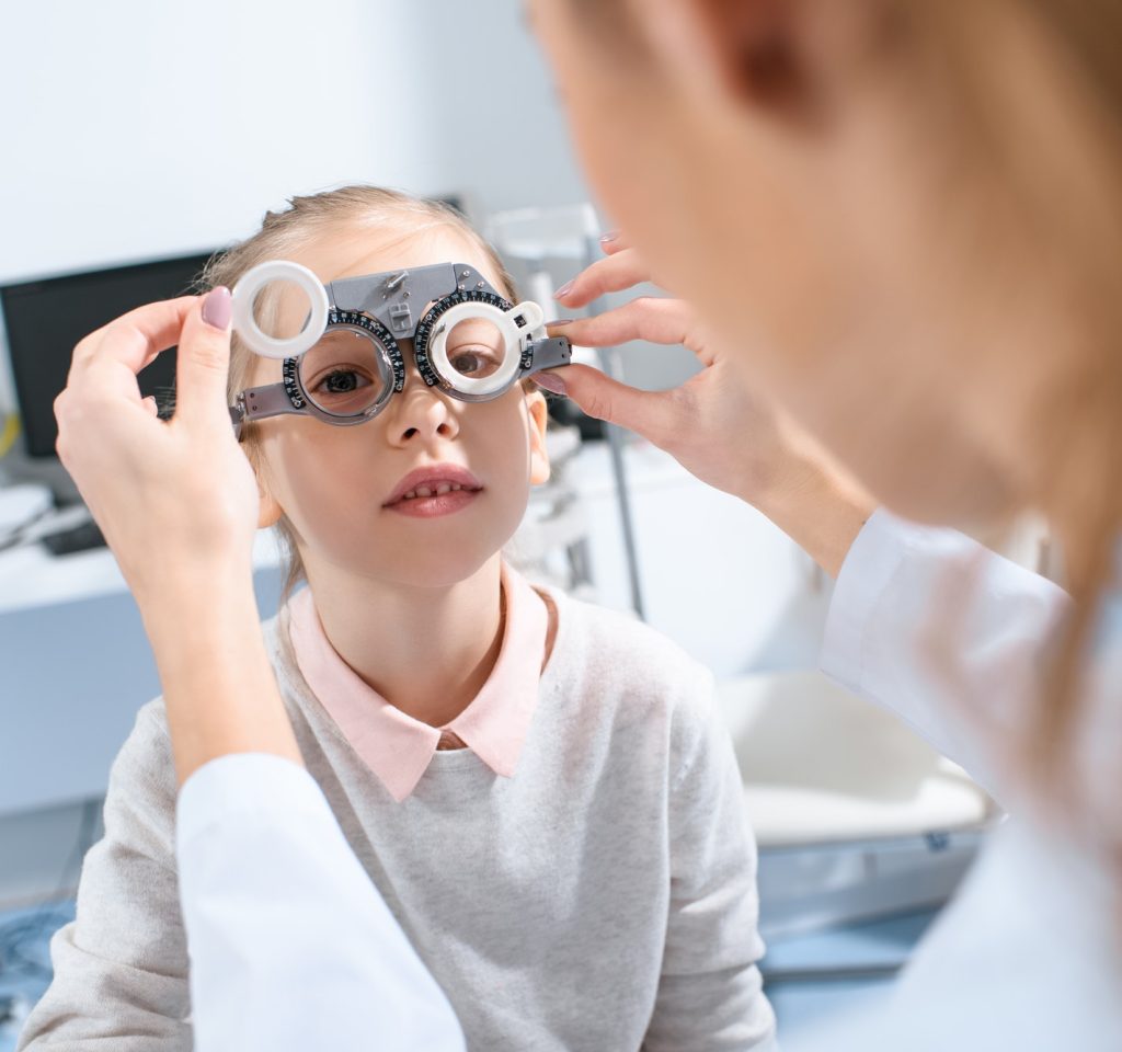 selective-focus-of-ophthalmologist-examining-kid-eyes-with-trial-frame-in-clinic.jpg